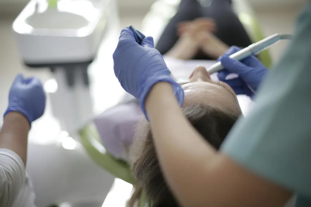 Dentistas realizando limpieza de caries a mujer